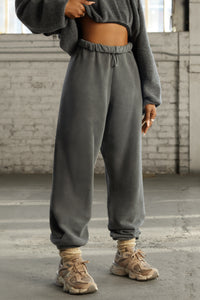 Front view of model from the waist down posing in the oversized loose fit washed black french terry Oversized Jogger with an elastic waistband and ankle cuffs