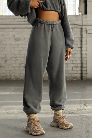 Front view of model from the waist down posing in the oversized loose fit washed black french terry Oversized Jogger with an elastic waistband and ankle cuffs