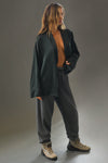 Full body front view of model posing in the comfortable, relaxed fit midnight Oversized Silk Button Down Long Sleeve top with a low shawl collar, front button closures and a left chest pocket