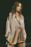 Front view of model posing in the comfortable, relaxed fit fawn Oversized Silk Button Down Long Sleeve top with a low shawl collar, front button closures and a left chest pocket