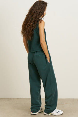Full body back view of model posing in the relaxed fit alpine french terry Oversized Straight Leg Jogger with an elastic waistband, hidden drawstring, pocket details. and adjustable cinching at the ankle cuffs