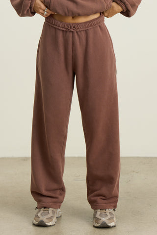 Front view of model from the waist down posing in the relaxed fit cedar french terry Oversized Straight Leg Jogger with an elastic waistband, hidden drawstring, pocket details. and adjustable cinching at the ankle cuffs