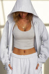 Front view of model posing in the oversized comfortable pearl grey french terry Oversized Zip Hoodie with a full length front zip closure, side pockets and thumbholes in the fitted cuffs