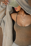 Close up detail front view of model posing in the oversized comfortable sand french terry Empire Zip Hoodie with a full length front zip closure, side pockets and thumbholes in the fitted cuffs