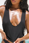 Close up detail front view of model posing in the lightweight relaxed fit black modal Plunge Tank with a plunging u-neckline