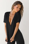 Front view of model posing in the full length relaxed fit black modal Plunge V Neck Tee with an plunging v-neckline