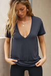 Front view of model posing in the full length relaxed fit navy modal Plunge V Neck Tee with an plunging v-neckline