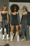 Three models posing in three different black tank and bottom Joah Brown outfits