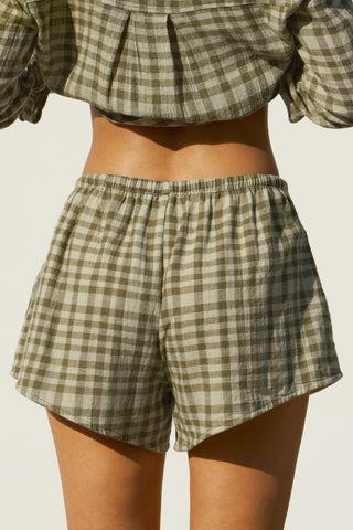 Close up back view of model from the waist down posing in the relaxed fit lightweight orchard gauze Relaxed Everyday Short with an elastic waistband and adjustable front tie