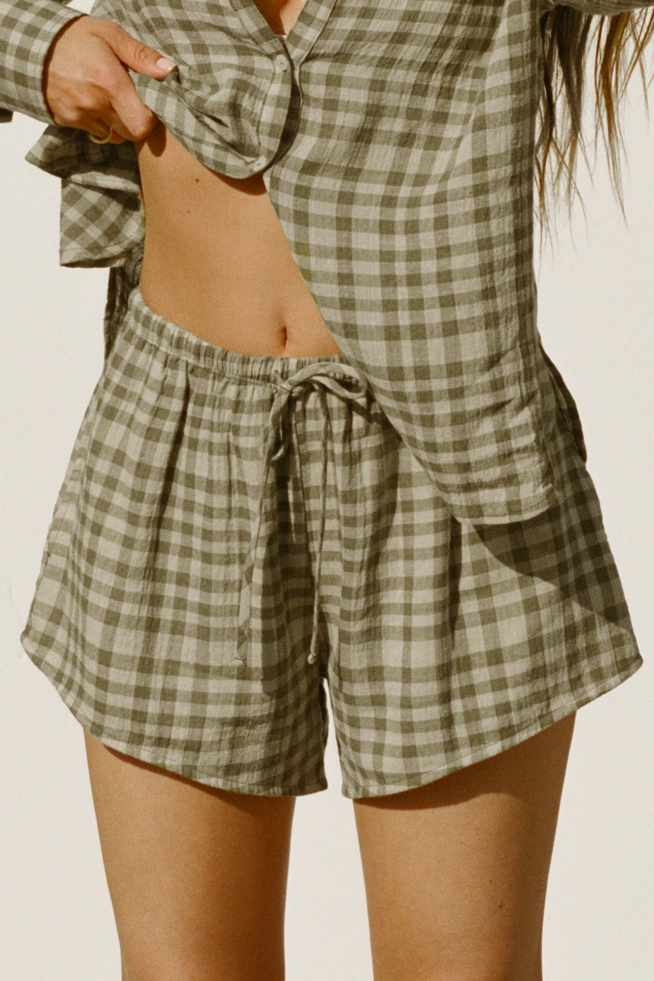 Close up front view of model from the waist down posing in the relaxed fit lightweight orchard gauze Relaxed Everyday Short with an elastic waistband and adjustable front tie