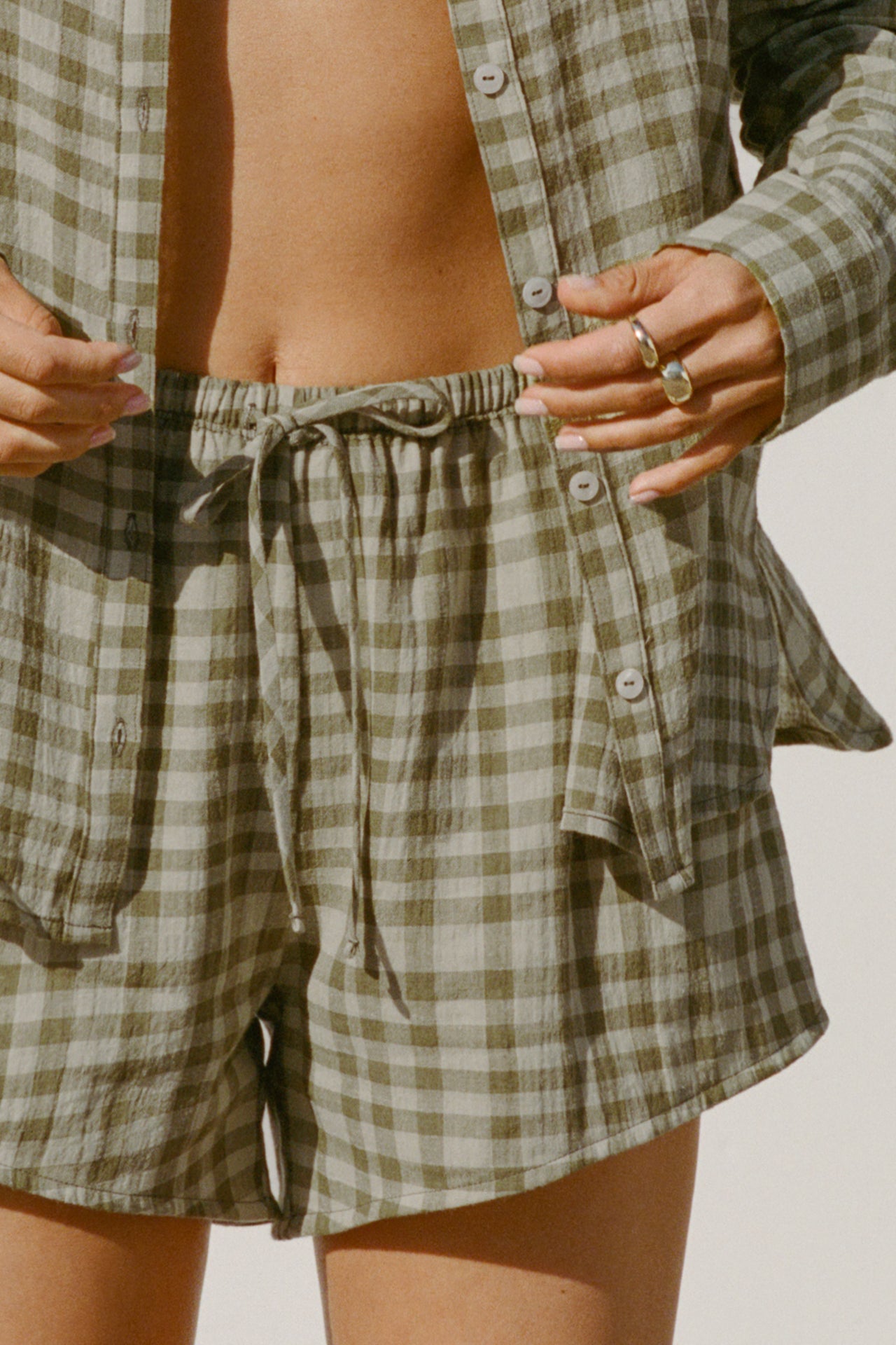 Close up front view of model from the waist down posing in the relaxed fit lightweight orchard gauze Relaxed Everyday Short with an elastic waistband and adjustable front tie