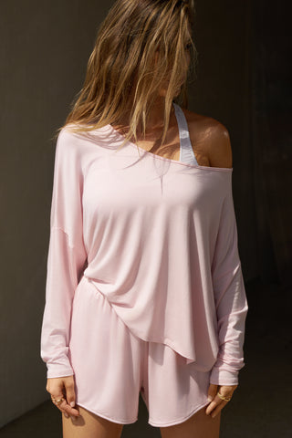 Front view of model posing in the full-length blush modal Relaxed Long Sleeve top with dropped shoulders and a wide neckline that can be worn off the shoulders.