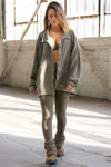 Full body front view of model posing in the loose-fitting oakmoss sherpa Relaxed Shirt Jacket with a classic collar, front button closures, side pockets, and a curved hem.