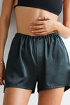 Close up front view of model posing in the comfortable, boxer-style midnight Relaxed Silk Short with an elastic waistband