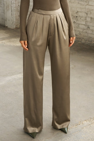 Front view of model from the waist down posing in the soft and smooth classic pleated saebrush  Relaxed Silk Trouser with a flattering wide leg, zip fly and side pockets.