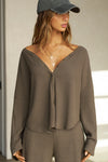 Front view of model posing in the relaxed-fit, long sleeve army luxe knit Relaxed V-Neck Cardigan with front button closures and a V-neckline.