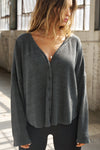 Front view of model posing in the relaxed-fit, long sleeve ink luxe knit Relaxed V-Neck Cardigan with front button closures and a V-neckline.