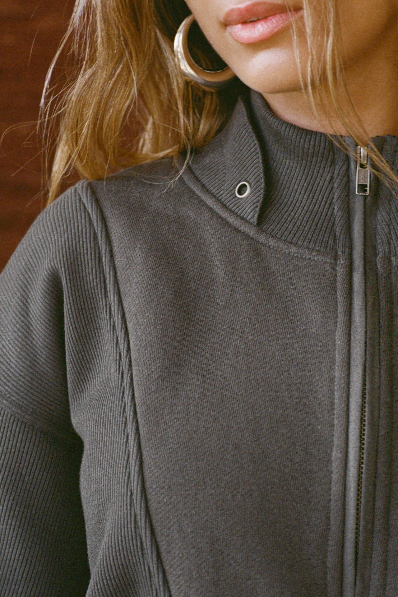 Close up detail front view of model posing in the oversized comfortable charcoal luxe french terry Retro Half Zip pullover sweatshirt with ribbed accents on the chest and sleeves, a hidden kangaroo pocket and a half zip collar