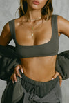 Close up front view of model posing in the fitted and stretchy mineral flexrib Scoop Neck Bra top with a scoop neckline