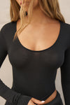 Close up detail front view of model posing the fitted lightweight black modal Scoop Neck Long Sleeve top with a deep scoop neckline and fitted sleeves