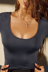 Close up front view of model posing the fitted lightweight navy modal Scoop Neck Long Sleeve top with a deep scoop neckline and fitted sleeves