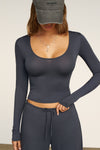 Front view of model posing the fitted lightweight navy modal Scoop Neck Long Sleeve top with a deep scoop neckline and fitted sleeves