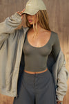 Front view of model posing in the fitted lightweight spruce modal Scoop Neck Long Sleeve top with a deep scoop neckline and fitted sleeves