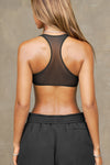 Back view of model posing in the sheer black mesh Scoop Neck Racerback Bra with a raceback silhouette