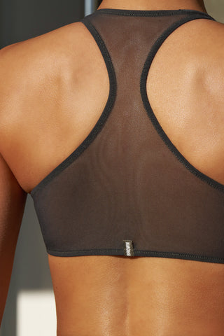 Close up detail back view of model posing in the sheer graphite mesh Scoop Neck Racerback Bra with a racerback silhouette