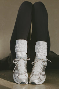 Front view of model posing in the slouchy classic white Scrunch Sock with extra long ribbed cuffs