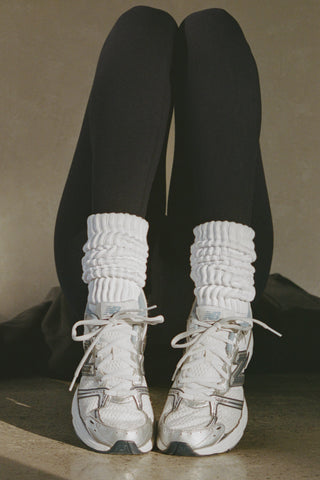 Front view of model posing in the slouchy classic white Scrunch Sock with extra long ribbed cuffs
