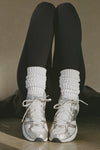 Front view of model posing in the slouchy classic white Scrunch Sock with extra long ribbed cuffs