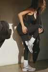 Full body side view of model posing in the slouchy classic white Scrunch Sock with extra long ribbed cuffs