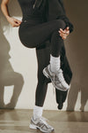 Side view of model from the waist down posing in the slouchy classic white Scrunch Sock with extra long ribbed cuffs