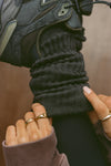 Close up detail side view of model adjusting the slouchy coal Scrunch Sock with extra long ribbed cuffs