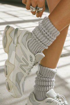 Close up side view of model adjusting the  slouchy salt Scrunch Sock with extra long ribbed cuffs