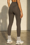 Back view of model from the waist down posing the full length and high-waisted sueded carob Second Skin Legging with a wide, v-shaped waistband