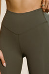 Close up detailed front view of model from the waist down posing the full length and high-waisted sueded carob Second Skin Legging with a wide, v-shaped waistband