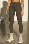 Front view of model from the waist down posing the full length and high-waisted sueded carob Second Skin Legging with a wide, v-shaped waistband