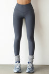 Front view of model from the waist down posing the full length and high-waisted sueded navy Second Skin Legging with a wide, v-shaped waistband