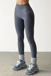 Front view of model from the waist down posing the full length and high-waisted sueded navy Second Skin Legging with a wide, v-shaped waistband