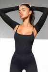 Front view of model posing in the ultra cropped black modal Shrug cardigan with fitted long sleeves