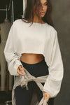 Front view of model posing in the cropped relaxed fit fog cotton Slouchy Crop Long Sleeve top with a crew neckline, dropped shoulders and oversized sleeves
