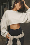 Front view of model posing in the cropped relaxed fit fog cotton Slouchy Crop Long Sleeve top with a crew neckline, dropped shoulders and oversized sleeves