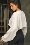 Back view of model posing in the cropped relaxed fit fog cotton Slouchy Crop Long Sleeve top with a crew neckline, dropped shoulders and oversized sleeves