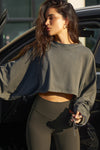 Front view of model posing in the cropped relaxed fit haze cotton Slouchy Crop Long Sleeve top with a crew neckline, dropped shoulders and oversized sleeves