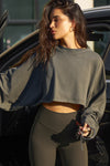 Front view of model posing in the cropped relaxed fit haze cotton Slouchy Crop Long Sleeve top with a crew neckline, dropped shoulders and oversized sleeves