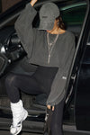 Front view of model posing in a car in the cropped relaxed fit washed black cotton Slouchy Crop Long Sleeve top with a crew neckline, dropped shoulders and oversized sleeves