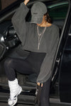 Front view of model posing in a car in the cropped relaxed fit washed black cotton Slouchy Crop Long Sleeve top with a crew neckline, dropped shoulders and oversized sleeves