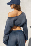Back view of model posing in the oversized heritage washed navy french terry Slouchy Pullover Sweatshirt with a wide, off-the-shoulder neckline and a JOAH BROWN logo patch on the right sleeve